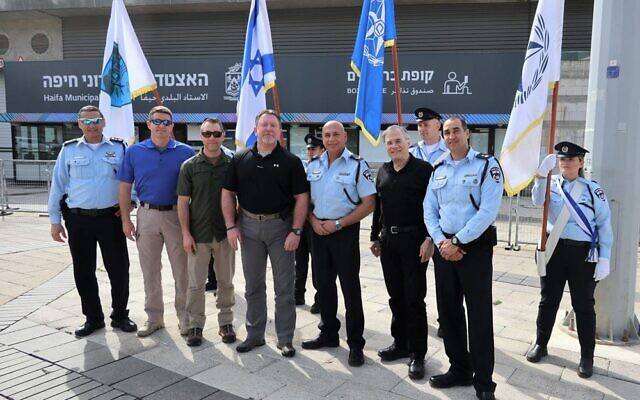 GILEE founder Robbie Friedmann standing with uniformed Israeli police officers.